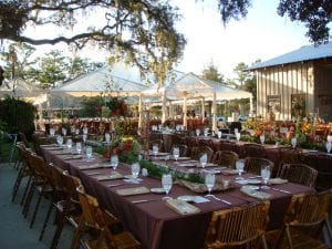 Wedding on a private country estate featuring clear top tents installed on a custom built wood floor and bamboo chairs.