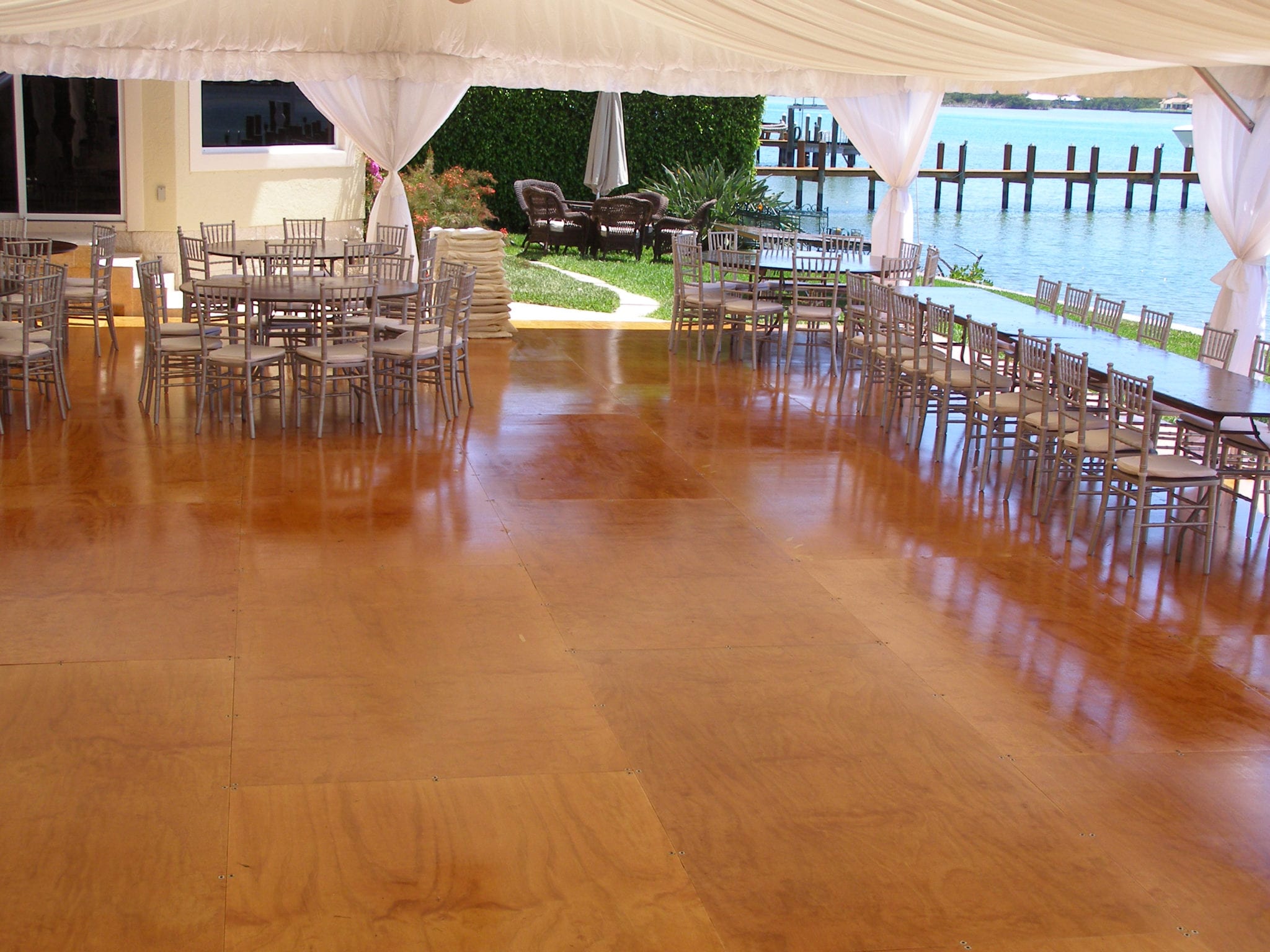 Custom built stained and varnished wood floor in a 30' x 70' frame tent.