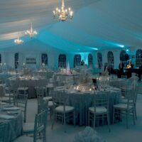 50' x 90' tent liner with chandeliers and back lit in blue lighting.