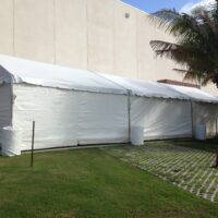 20' x 60' gable ended frame tent with white sidewalls.