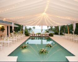 Wedding at a private waterfront home featuring a 40' x 60' frame tent with tent liner, leg drapes, and market lighting.