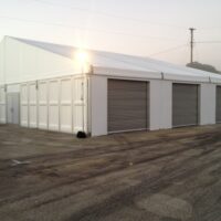 20m x 15m structure tent with custom made and installed roll up garagae doors and PVC hard walls.