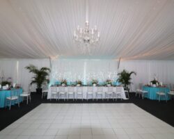 Wedding for 140 guests in a 40' x 80' frame tent featuring a tent liner, crstal chandelier, and gloss white dance floor.